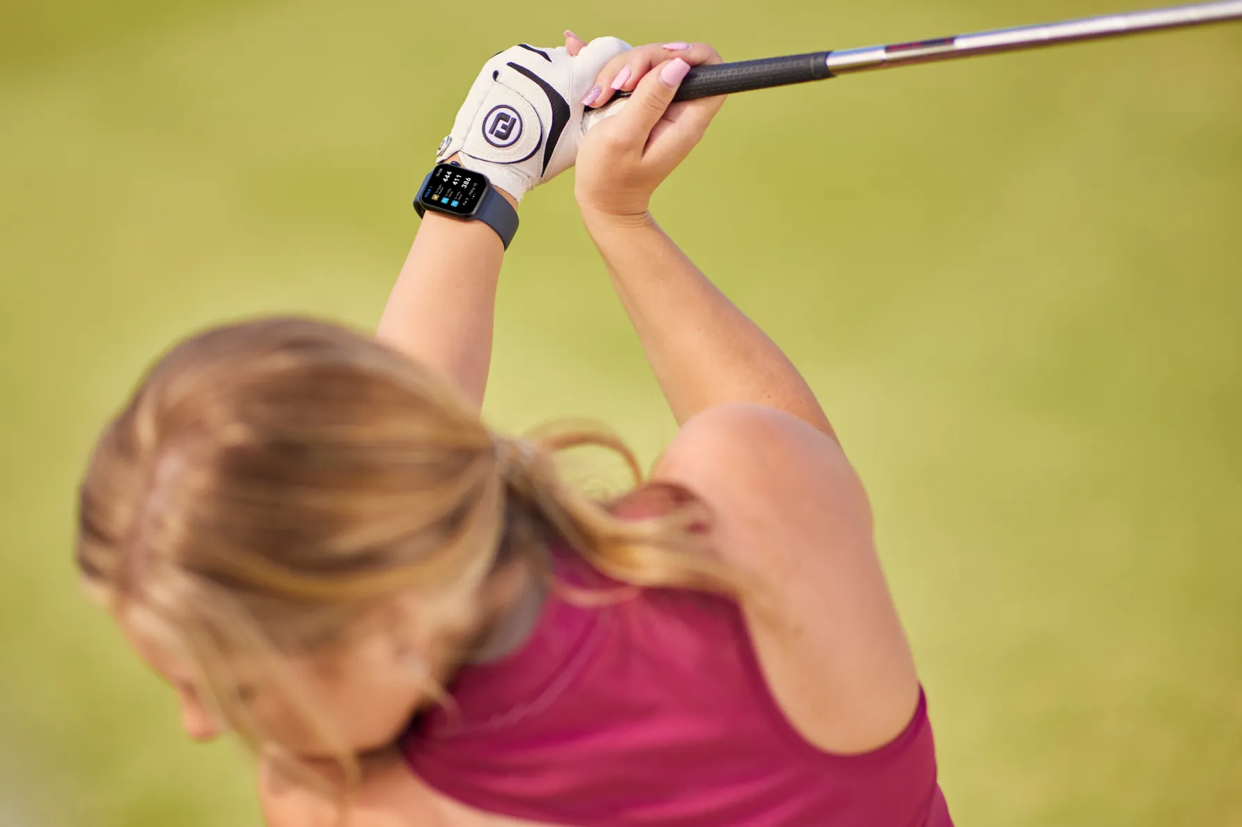 a woman swinging a golf club at a ball