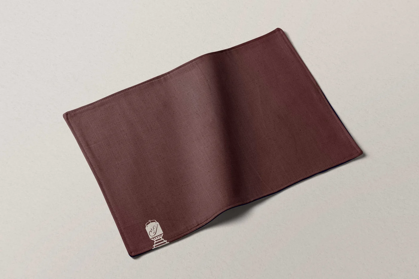 Empty maroon cloth napkin with a small logo — The Junction Stouffville case study