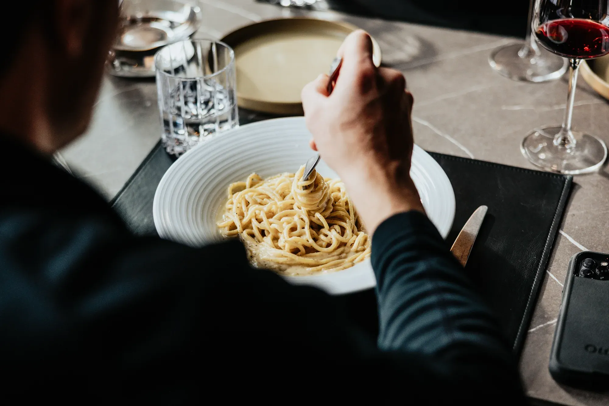 imgi Person eating spaghetti at table — The Junction Stouffville case study
