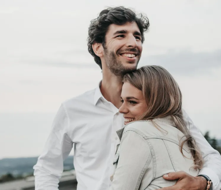 A lovely couple of honeymooners hugging and smiling